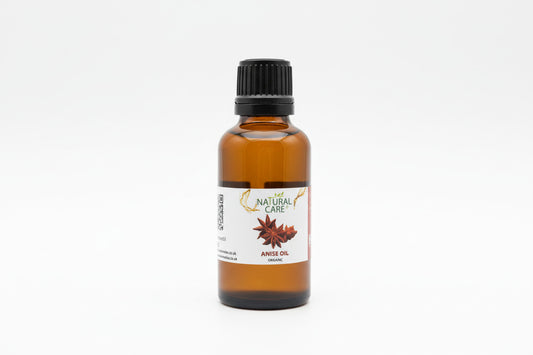 Bottle of anise oil with a 'Natural Care' label on a wooden surface