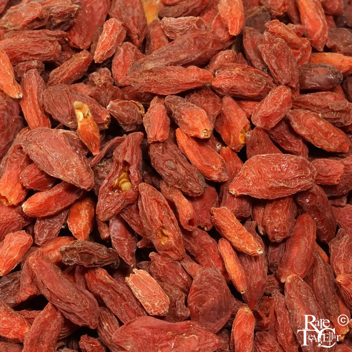 Close-up of dried goji berries with a brand name in the corner.