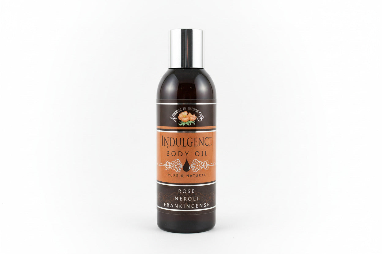 Bottle of Indulgence body oil on a light gray background