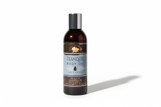 Bottle of Tranquil Body Oil on a light surface next to a keyboard