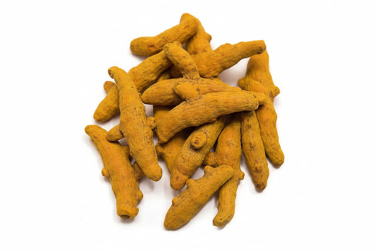 Turmeric root pieces on a white background