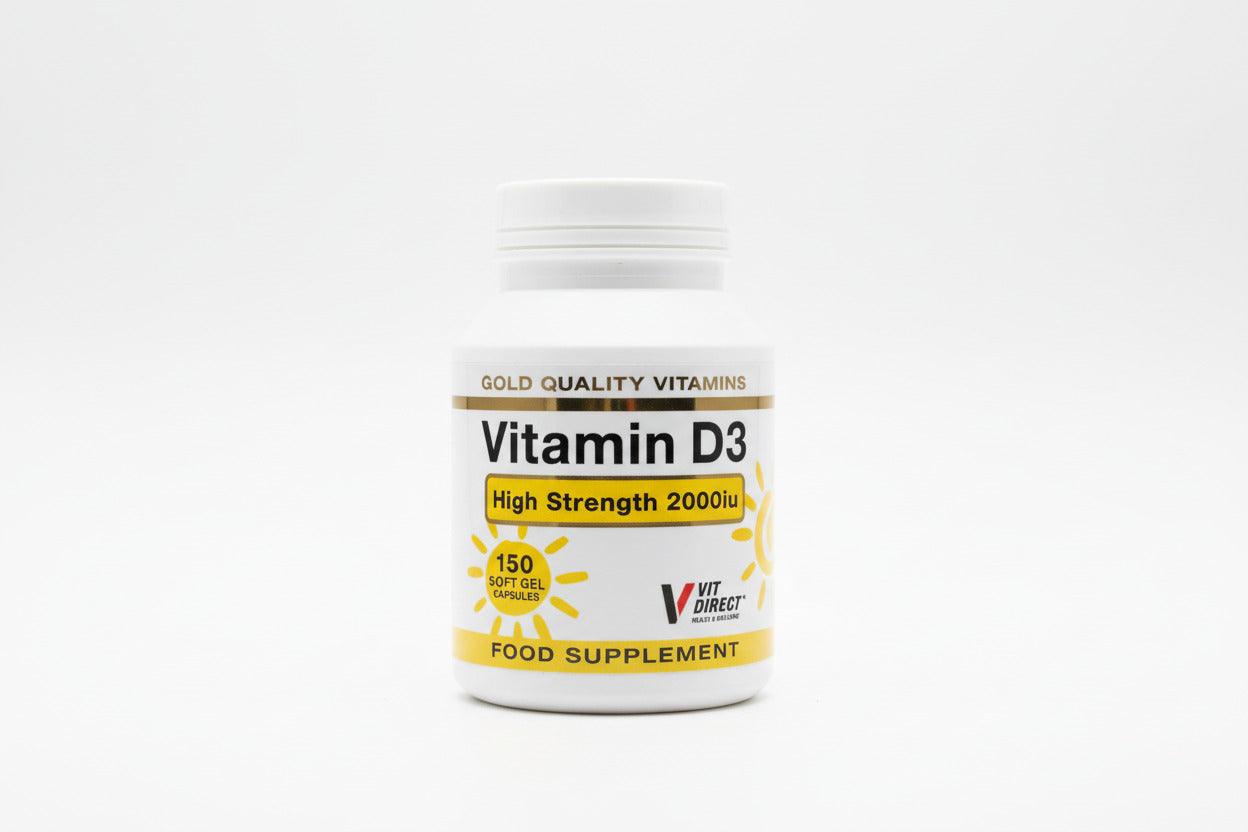 Vitamin D3 supplement bottle held by a hand on a light surface.
