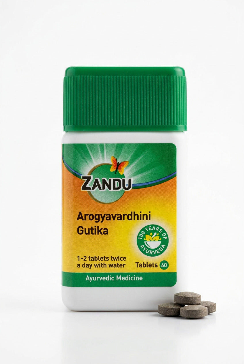A bottle of Zandu Arogyavardhini Gutika ayurvedic tablets, featuring a green cap and a green, yellow, and orange label, placed on a wooden surface.