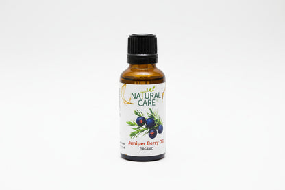 A bottle of Organic Juniperberry Essential Oil with a label showing the brand name, product name, and an image of juniper berries. The bottle is filled with a clear liquid.