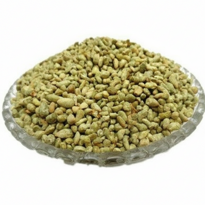 Greenish-brown seeds in a glass bowl on a white background
