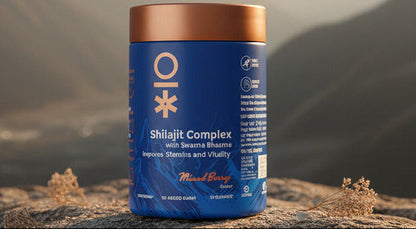 A blue plastic tub of OI Shilajit Complex with Swarna Bhasma gummies in Mixed Berry flavor, featuring a metallic copper lid, set on a wooden surface.