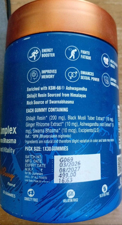 A blue plastic supplement jar with a metallic copper lid, showing the back label with text and icons on a wooden surface.